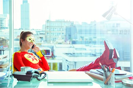 simsearch:6113-07961683,k - Superhero talking on cell phone at office desk Stock Photo - Premium Royalty-Free, Code: 6113-07961699