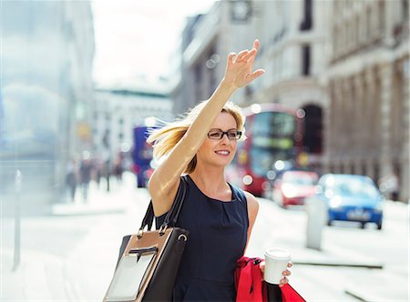 Businesswoman hailing taxi in city Stock Photo - Premium Royalty-Free, Code: 6113-07961614