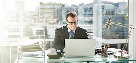 simsearch:6113-08171454,k - Businessman working on laptop in office Stock Photo - Premium Royalty-Free, Code: 6113-07961753