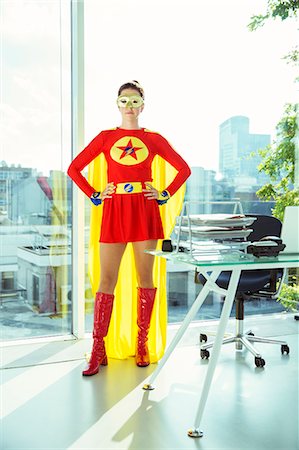 Superhero standing with hands on hips in office Stock Photo - Premium Royalty-Free, Code: 6113-07961703