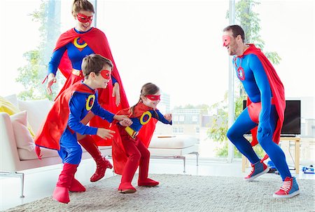 simsearch:6113-07961735,k - Superhero family chasing each other in living room Foto de stock - Sin royalties Premium, Código: 6113-07961705