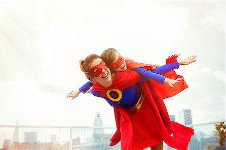 flying happy woman images - Superhero mother and daughter playing on city rooftop Photographie de stock - Premium Libres de Droits, Code: 6113-07961722