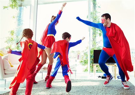 father mother child laughing white - Superhero family playing in living room Stock Photo - Premium Royalty-Free, Code: 6113-07961726