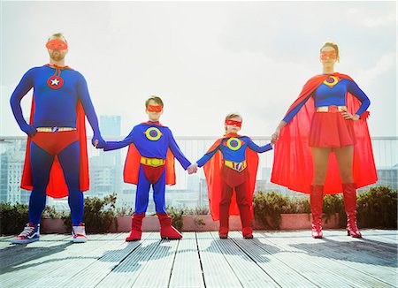 Superhero family holding hands on city rooftop Foto de stock - Sin royalties Premium, Código: 6113-07961735