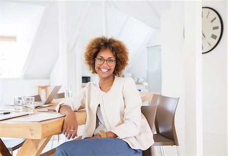 south africa - Portrait of woman sitting at desk in office and smiling Stock Photo - Premium Royalty-Free, Code: 6113-07991871