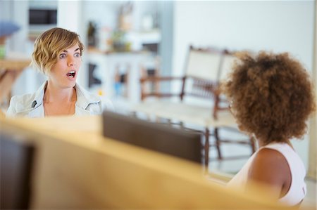 south africa photo people - Female colleagues talking in office, feeling surprised Stock Photo - Premium Royalty-Free, Code: 6113-07991877