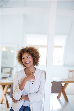 portrait of businesswoman - Portrait of woman leaning on column in office and smiling Stock Photo - Premium Royalty-Free, Code: 6113-07991876