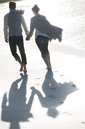 simsearch:841-03870164,k - Young couple holding hands and walking on beach Foto de stock - Sin royalties Premium, Código: 6113-07992055
