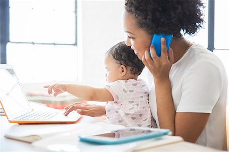 south africa - Mother working from home with daughter sitting on her lap Foto de stock - Sin royalties Premium, Código: 6113-07992092