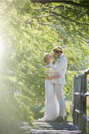 simsearch:6113-07992154,k - Young couple embracing on wooden bridge Foto de stock - Sin royalties Premium, Código: 6113-07992157