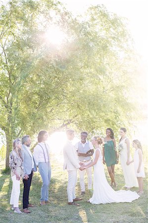 Young couple and guests during wedding ceremony in domestic garden Photographie de stock - Premium Libres de Droits, Code: 6113-07992181