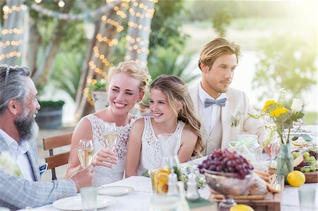 simsearch:6113-07992187,k - Young couple and their guests sitting at table during wedding reception in garden Foto de stock - Sin royalties Premium, Código: 6113-07992120