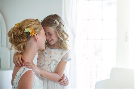 Bride and bridesmaid facing each other and smiling in bedroom Photographie de stock - Premium Libres de Droits, Code: 6113-07992138