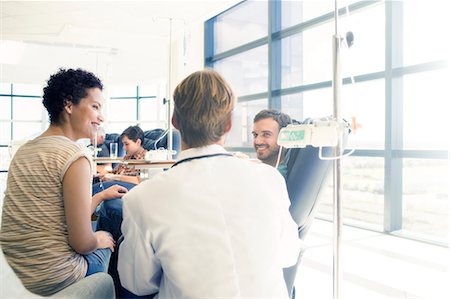 Doctor talking to patient receiving medical treatment in hospital ward Stock Photo - Premium Royalty-Free, Code: 6113-07905842