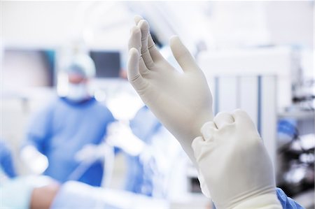 Close-up of surgeon putting on surgical gloves in operating theater Stockbilder - Premium RF Lizenzfrei, Bildnummer: 6113-07905869