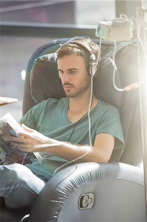 simsearch:6113-07905882,k - Male patient reading magazine while receiving intravenous infusion in hospital Stock Photo - Premium Royalty-Free, Code: 6113-07905872