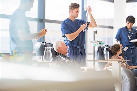 Doctors attending patients receiving intravenous infusion in hospital Photographie de stock - Premium Libres de Droits, Code: 6113-07905879