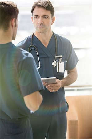 simsearch:6113-07905882,k - Two male doctors talking, one holding tablet pc Stock Photo - Premium Royalty-Free, Code: 6113-07905891