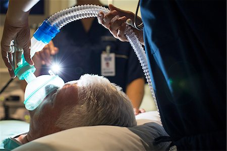 Female doctor wearing mask while anesthetizing elderly patient in surgery Photographie de stock - Premium Libres de Droits, Code: 6113-07905817