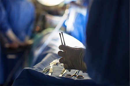 sala operatoria - Nurse holding surgical tools during surgery Fotografie stock - Premium Royalty-Free, Codice: 6113-07905829