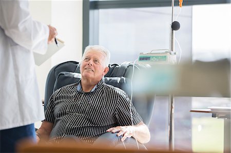Doctor talking to patient receiving medical treatment in hospital ward Stock Photo - Premium Royalty-Free, Code: 6113-07905837