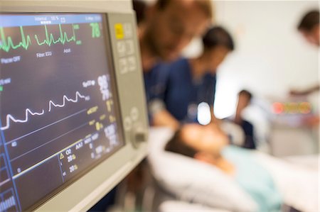 Heart rate monitor, patient and doctors in background in intensive care unit Photographie de stock - Premium Libres de Droits, Code: 6113-07905941