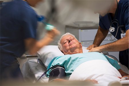 people laying in hospital beds - Senior patient receiving medical treatment in intensive care unit Stock Photo - Premium Royalty-Free, Code: 6113-07905947