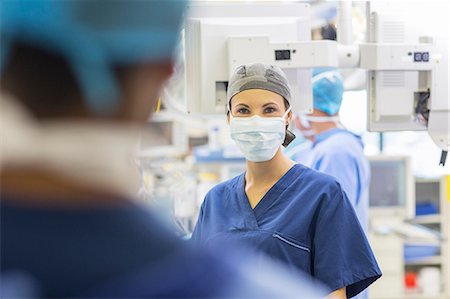 simsearch:6113-07905909,k - Female doctor wearing surgical cap and mask looking at camera Stock Photo - Premium Royalty-Free, Code: 6113-07905997