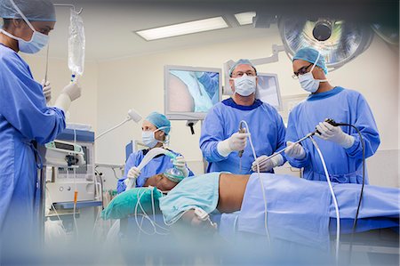 simsearch:6113-07905962,k - Team of surgeons operating on patient in hospital Photographie de stock - Premium Libres de Droits, Code: 6113-07905905