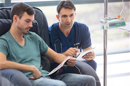 doctor discussing patient - Doctor holding digital tablet, talking to patient undergoing medical treatment in hospital Stock Photo - Premium Royalty-Free, Code: 6113-07905914