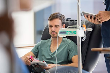 patient infusion chair - Patient reading magazine, undergoing medical treatment in outpatient clinic Stock Photo - Premium Royalty-Free, Code: 6113-07905915