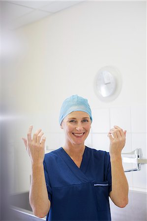 simsearch:6113-07905909,k - Portrait of smiling female doctor wearing surgical cap and gown in hospital Stock Photo - Premium Royalty-Free, Code: 6113-07905932