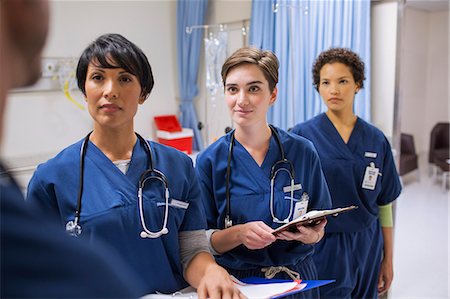 simsearch:6113-07905909,k - Team of female doctors wearing scrubs talking in hospital ward Stock Photo - Premium Royalty-Free, Code: 6113-07905939