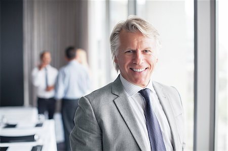 professional african portrait - Portrait of businessman standing in conference room with colleagues in background Stock Photo - Premium Royalty-Free, Code: 6113-07906055