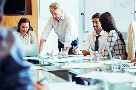 pensive mature brunette woman looking away - Business people having meeting in conference room, using laptop and discussing Stock Photo - Premium Royalty-Free, Code: 6113-07906073