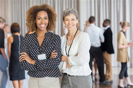 standing discussing - Businesswomen posing in front of colleagues in office Stock Photo - Premium Royalty-Free, Code: 6113-07906028