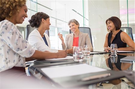 simsearch:6113-07808825,k - Businesswomen sitting at conference table talking Foto de stock - Royalty Free Premium, Número: 6113-07906032