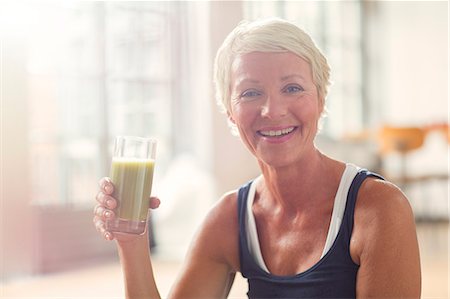 simsearch:6113-07906210,k - Smiling older woman drinking juice Foto de stock - Sin royalties Premium, Código: 6113-07906190