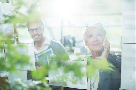 Businesswoman talking on cell phone in office Foto de stock - Sin royalties Premium, Código: 6113-07906267