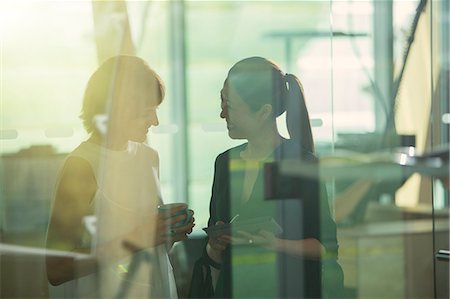 Businesswomen talking in office Foto de stock - Sin royalties Premium, Código: 6113-07906269