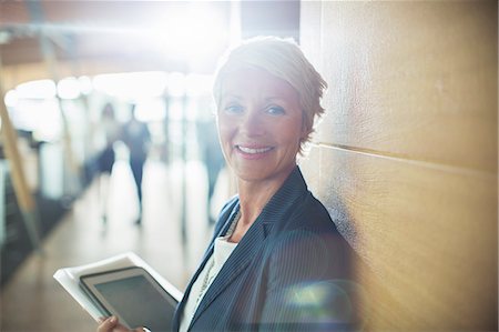 portrait of confident mature woman standing - Businesswoman carrying digital tablet in office Photographie de stock - Premium Libres de Droits, Code: 6113-07906299