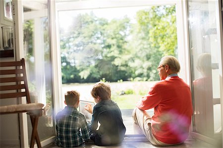 simsearch:6113-07906363,k - Grandfather and grandsons relaxing in doorway Stock Photo - Premium Royalty-Free, Code: 6113-07906355