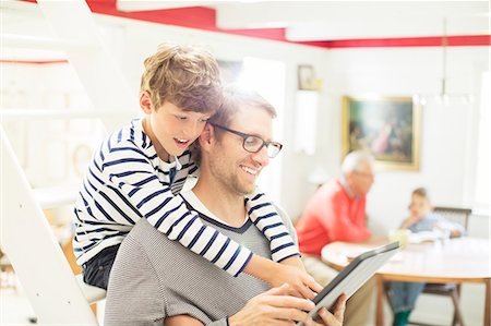 father son indoors - Father and son using digital tablet Stock Photo - Premium Royalty-Free, Code: 6113-07906358