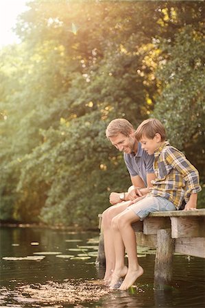 simsearch:6113-07906375,k - Father and son dangling feet in lake Stock Photo - Premium Royalty-Free, Code: 6113-07906374