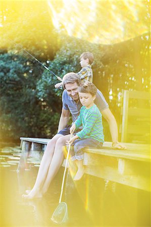 Father and sons fishing from dock Foto de stock - Sin royalties Premium, Código: 6113-07906379