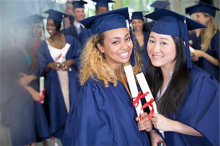 Portrait of smiling students with diplomas standing in corridor Stock Photo - Premium Royalty-Free, Code: 6113-07906447