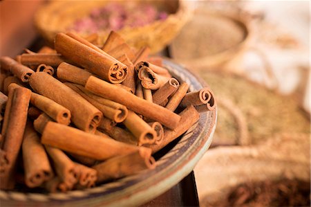 simsearch:6113-07906405,k - Cinnamon sticks on plate and other spices in background in spice market Foto de stock - Sin royalties Premium, Código: 6113-07906408