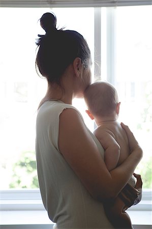 View of mother holding baby and looking through window Fotografie stock - Premium Royalty-Free, Codice: 6113-07906423