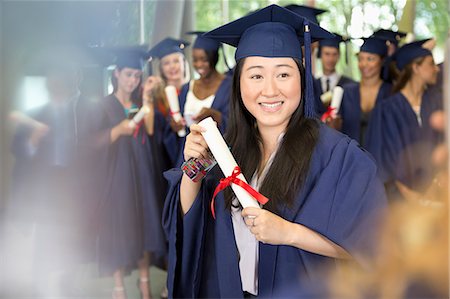 simsearch:6116-06939213,k - Portrait of smiling female student in graduation gown holding diploma Photographie de stock - Premium Libres de Droits, Code: 6113-07906560