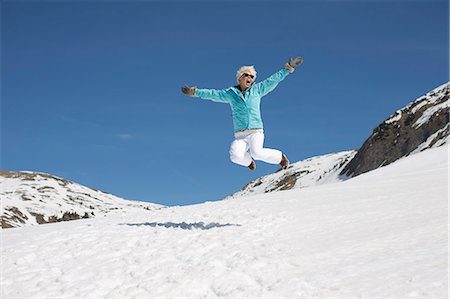 simsearch:6118-08023790,k - Exuberant woman jumping in snow Stock Photo - Premium Royalty-Free, Code: 6113-07906590